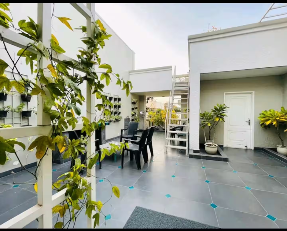 Green Cottage villa courtyard with vertical planters, vines, and outdoor seating